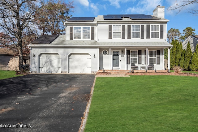 view of front of property with solar panels, a porch, a garage, and a front yard