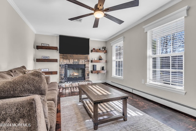 living room with a healthy amount of sunlight, ornamental molding, a fireplace, and a baseboard heating unit