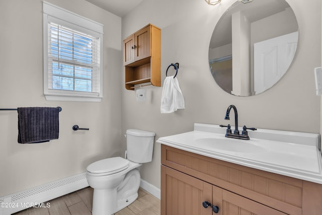 bathroom with hardwood / wood-style floors, vanity, toilet, and a baseboard heating unit