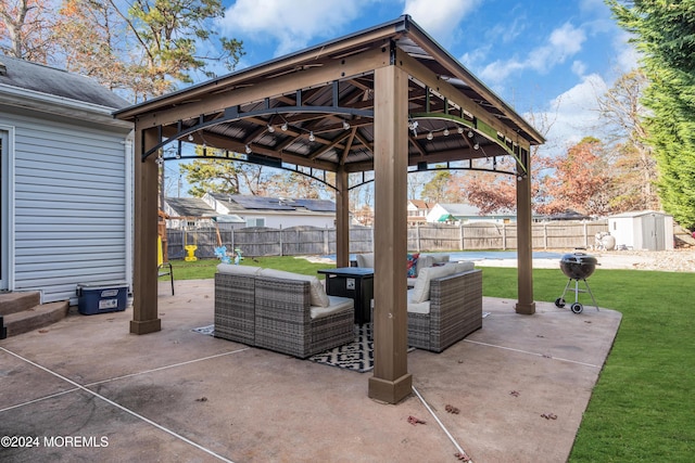 view of patio featuring a gazebo, an outdoor living space, and a storage unit