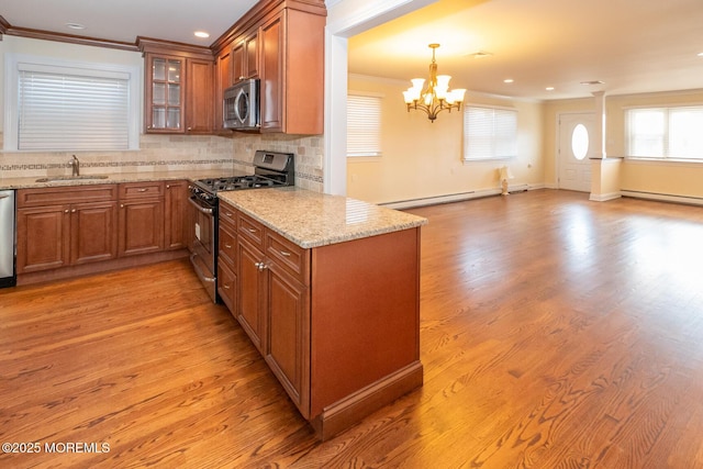 kitchen with sink, baseboard heating, appliances with stainless steel finishes, tasteful backsplash, and light stone countertops