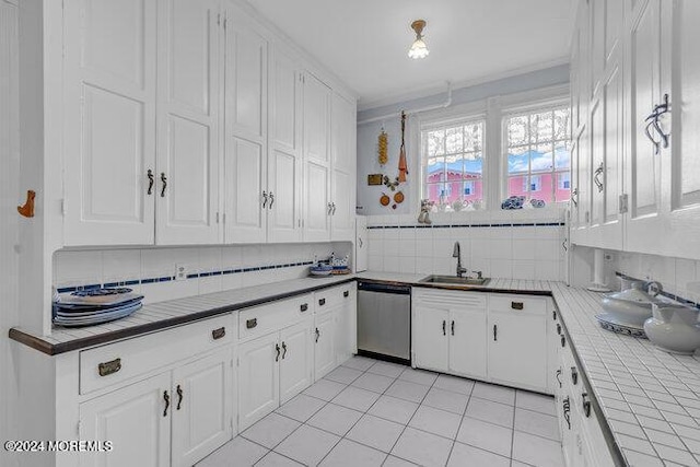 kitchen with white cabinetry, tile counters, dishwasher, sink, and tasteful backsplash