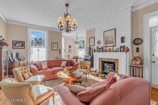 living room featuring a notable chandelier, wood-type flooring, crown molding, and a premium fireplace