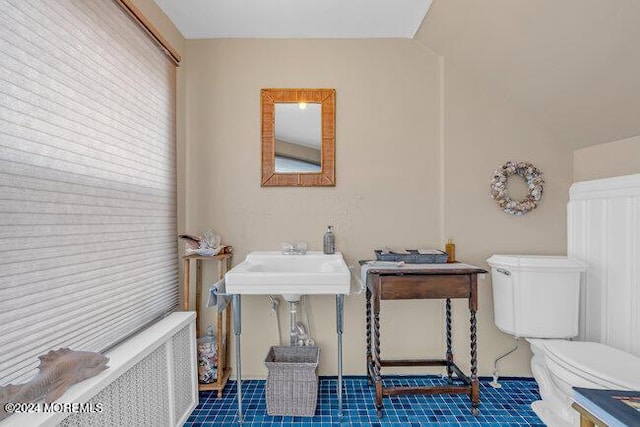 bathroom with tile patterned floors, sink, radiator heating unit, and toilet