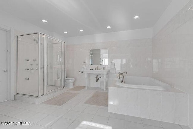 bathroom featuring tile patterned flooring, independent shower and bath, tile walls, and toilet