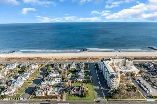 drone / aerial view with a water view and a beach view