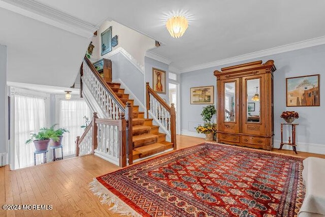 entrance foyer with crown molding and light hardwood / wood-style flooring