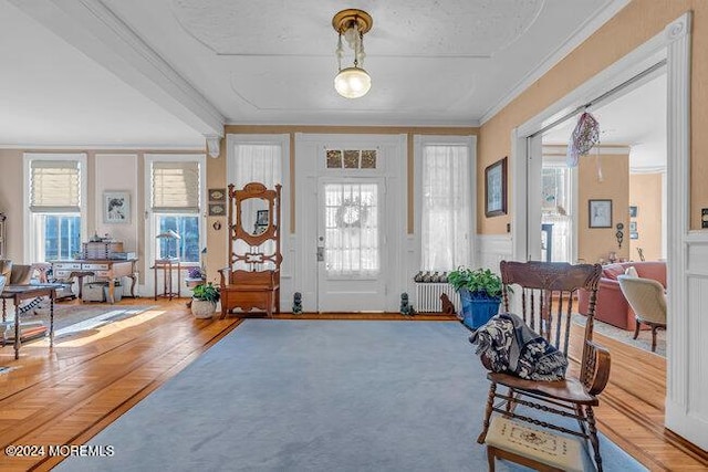 foyer with hardwood / wood-style floors, radiator, and ornamental molding