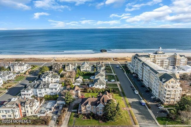 birds eye view of property with a water view and a beach view