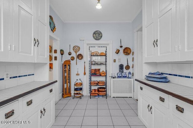 kitchen with decorative backsplash, white cabinets, and light tile patterned flooring