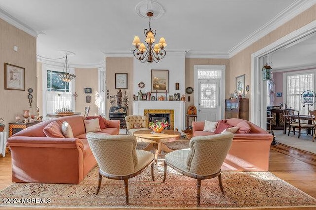 living room featuring light hardwood / wood-style floors, an inviting chandelier, and ornamental molding