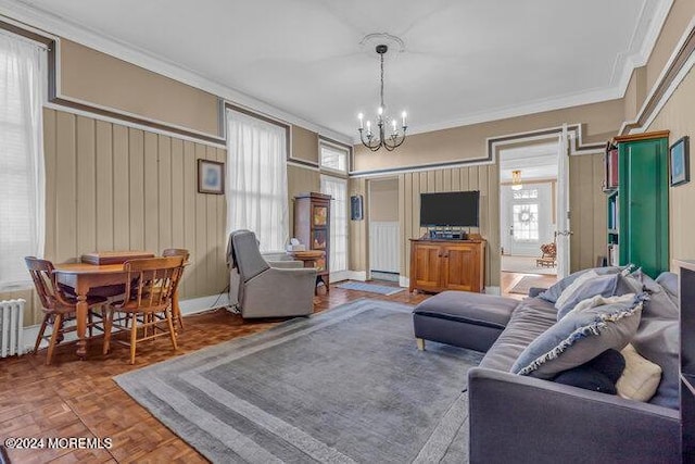 living room featuring dark parquet flooring, crown molding, and a notable chandelier