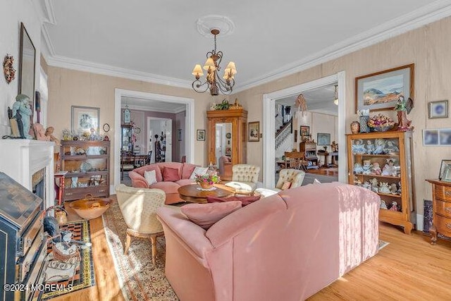 living room with light hardwood / wood-style floors, an inviting chandelier, and crown molding