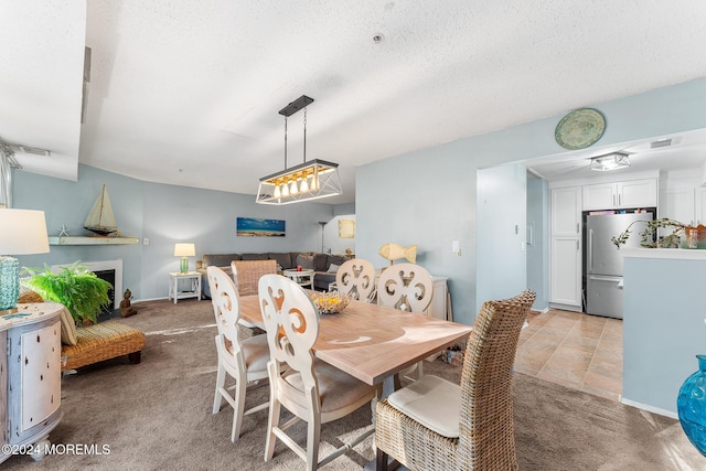 dining space with a textured ceiling and light carpet