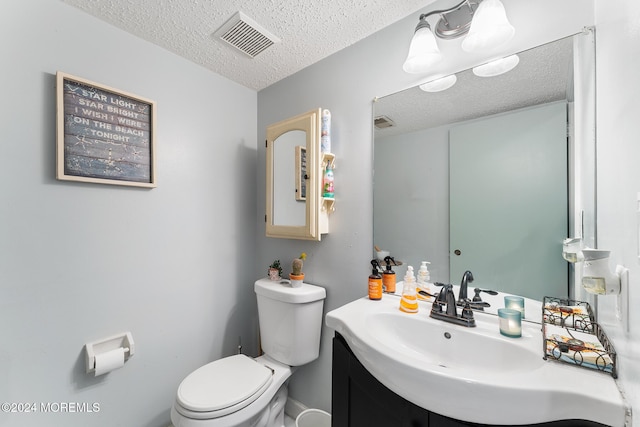 bathroom featuring vanity, toilet, and a textured ceiling