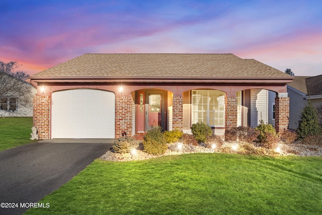 view of front facade featuring a garage and a yard