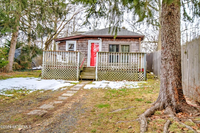 snow covered house featuring a deck