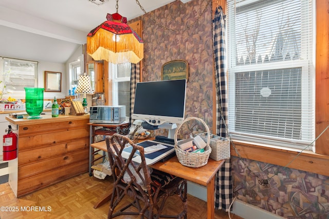 office featuring parquet flooring, vaulted ceiling with beams, and a healthy amount of sunlight