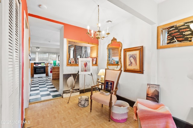 sitting room featuring light parquet flooring and a notable chandelier