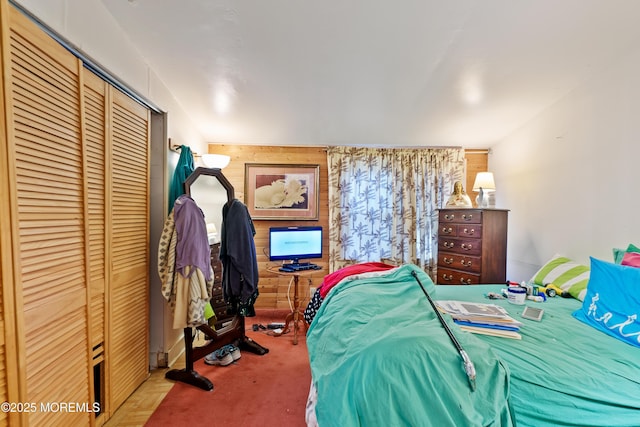 bedroom with a closet and wooden walls