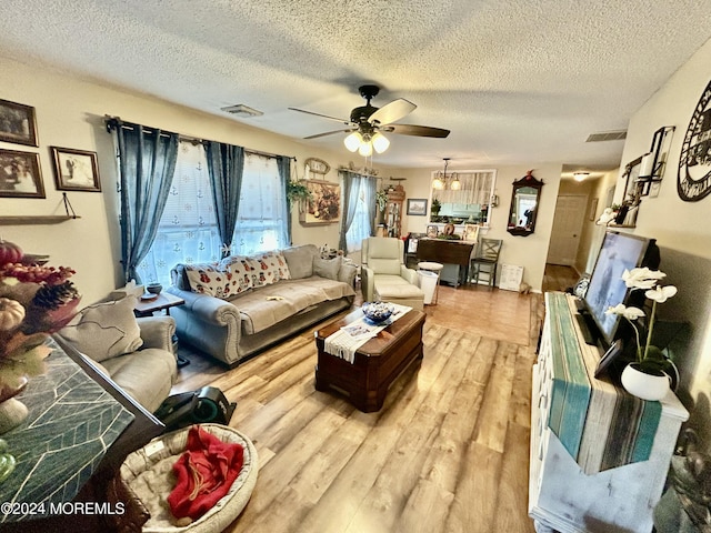 living room with ceiling fan, hardwood / wood-style floors, and a textured ceiling