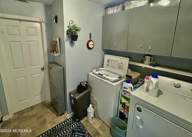 laundry room featuring washer and dryer and cabinets