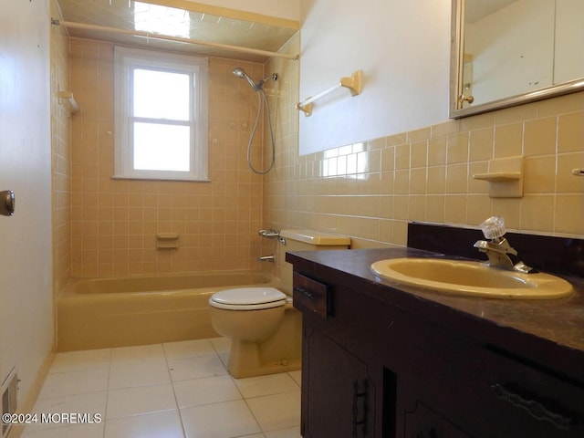 full bathroom with tile patterned floors, toilet, vanity, tile walls, and tiled shower / bath