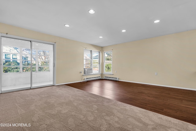 empty room with hardwood / wood-style flooring and baseboard heating