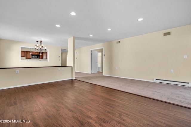 unfurnished living room featuring dark hardwood / wood-style flooring, baseboard heating, and a notable chandelier