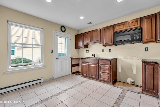 kitchen featuring light tile patterned floors, sink, and a baseboard heating unit