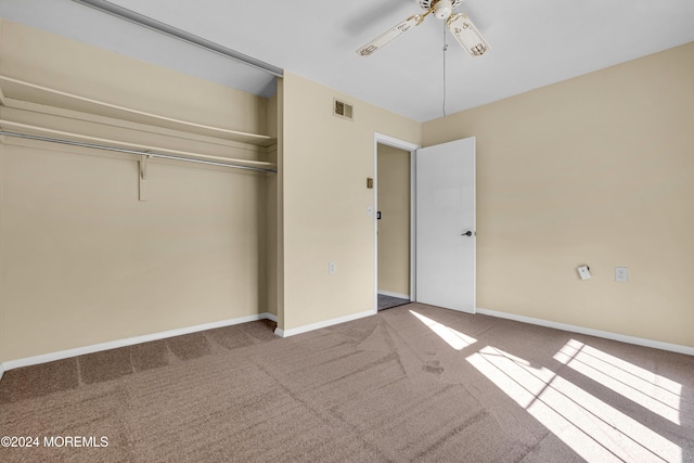 unfurnished bedroom featuring ceiling fan, a closet, and carpet