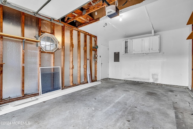 garage featuring electric panel and a garage door opener