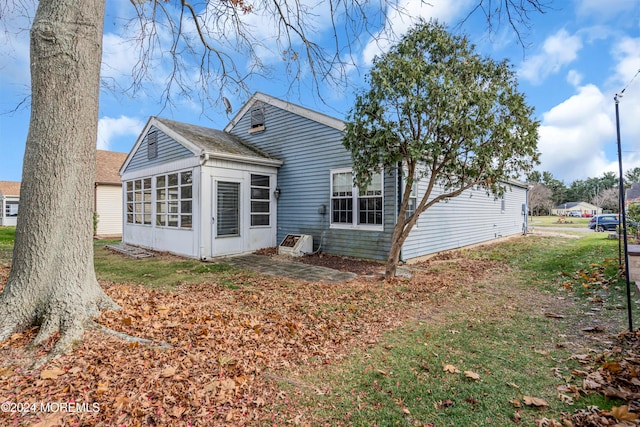 rear view of property featuring a sunroom