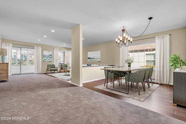 dining room with hardwood / wood-style flooring, a wealth of natural light, and an inviting chandelier