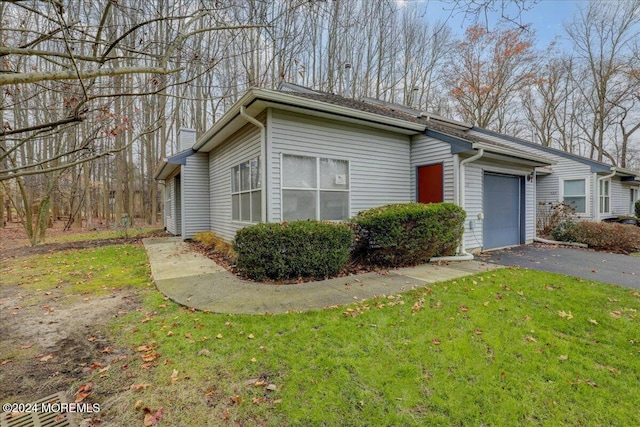 view of side of home with a garage and a lawn