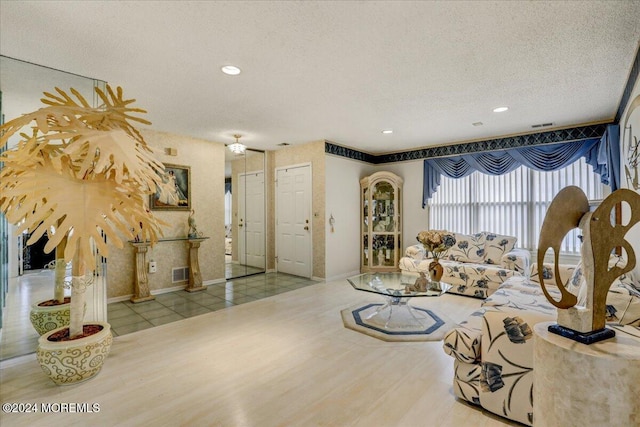 living room featuring light hardwood / wood-style flooring and a textured ceiling