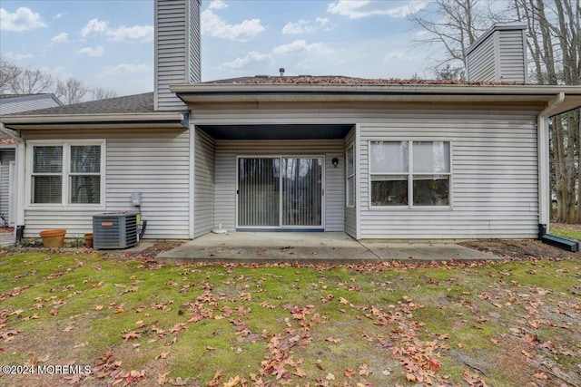 back of property with a patio, a lawn, and central air condition unit