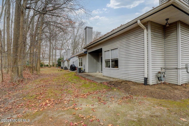 view of side of property with central AC unit and a patio