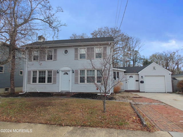 colonial-style house featuring a front lawn and a garage