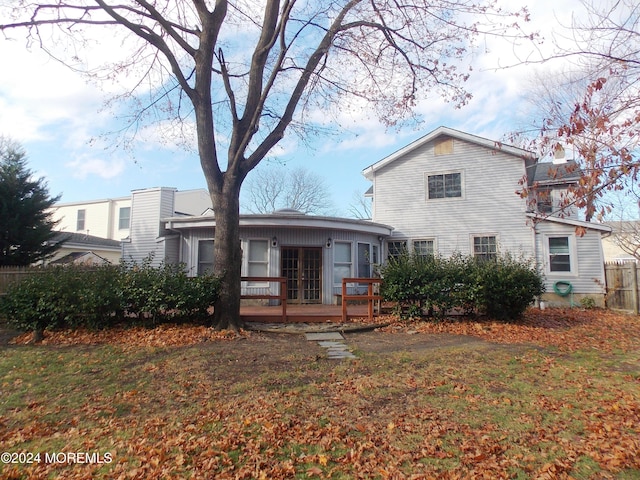 rear view of house featuring a yard, french doors, and a deck