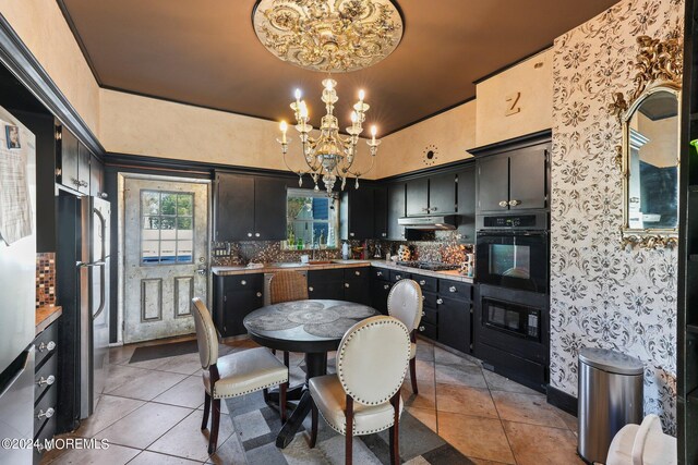 kitchen featuring backsplash, an inviting chandelier, sink, light tile patterned floors, and stainless steel appliances