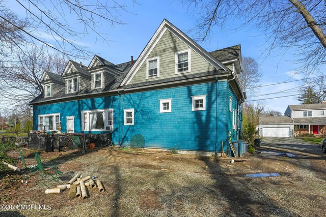 back of house featuring an outbuilding and a garage