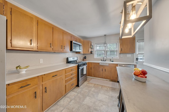 kitchen with appliances with stainless steel finishes, pendant lighting, and sink