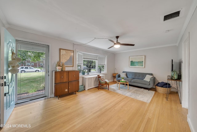 living room featuring crown molding, ceiling fan, and light hardwood / wood-style floors