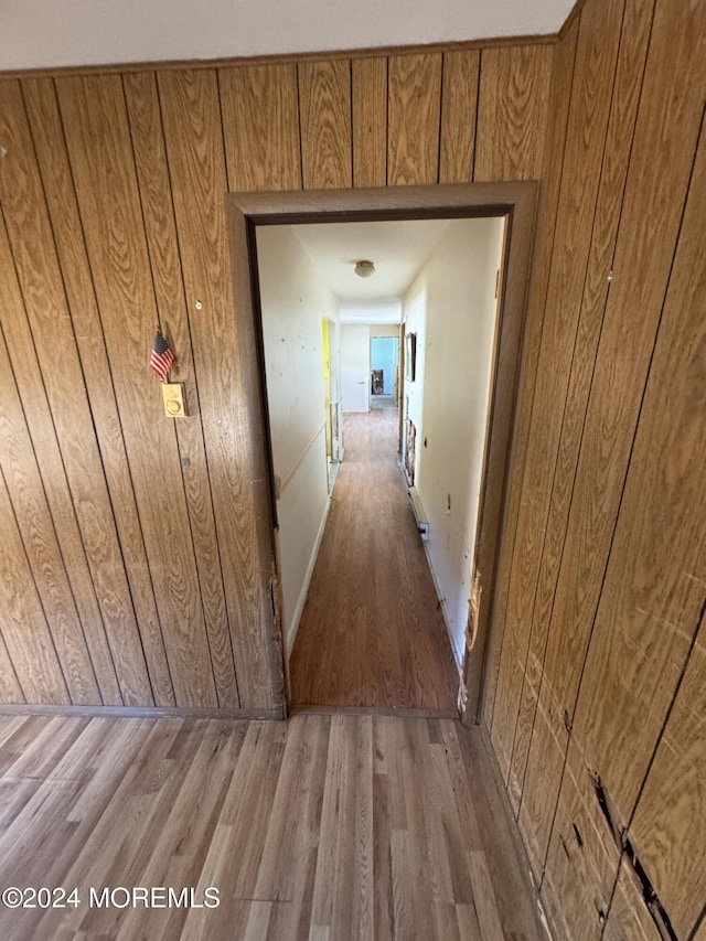 corridor featuring wood walls and light wood-type flooring