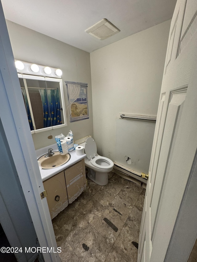 bathroom with baseboard heating, vanity, and toilet