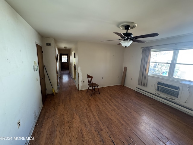 empty room with dark hardwood / wood-style flooring, a wall unit AC, and plenty of natural light