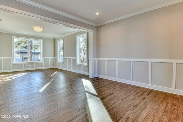 spare room featuring wood-type flooring and ornamental molding