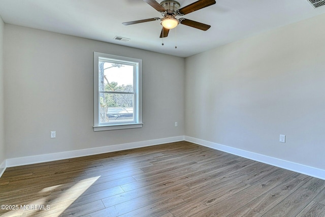 empty room with hardwood / wood-style floors and ceiling fan