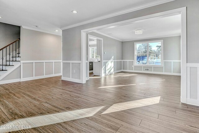 1032 3rd Ave, Toms River, NJ 08757 - empty room featuring wood finished floors, plenty of natural light, stairway, wainscoting, and ornamental molding